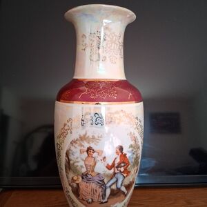 A vintage Japanese porcelain vase decorated with an image of a Victorian couple.